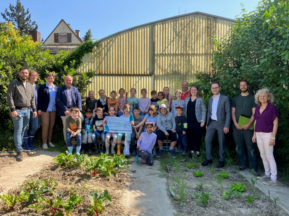 Die Klasse 3a mit Gästen (v.l.n.r.: Lehrer Florian Koch, Lehrerin Liliane Eberenz, Schulleiterin Daniela Wolber, Bürgermeister Dieter Schneckenburger, Klasse 3a, Unterstützer Wolfgang Fritzsche, Kathrin Höge (Sparkasse), Marc Winsheimer (Sparkasse), Michael Eisele (Ackercoach), Klassenlehrerin Ursula Klink-Flury) Scheckübergabe mit Kindern