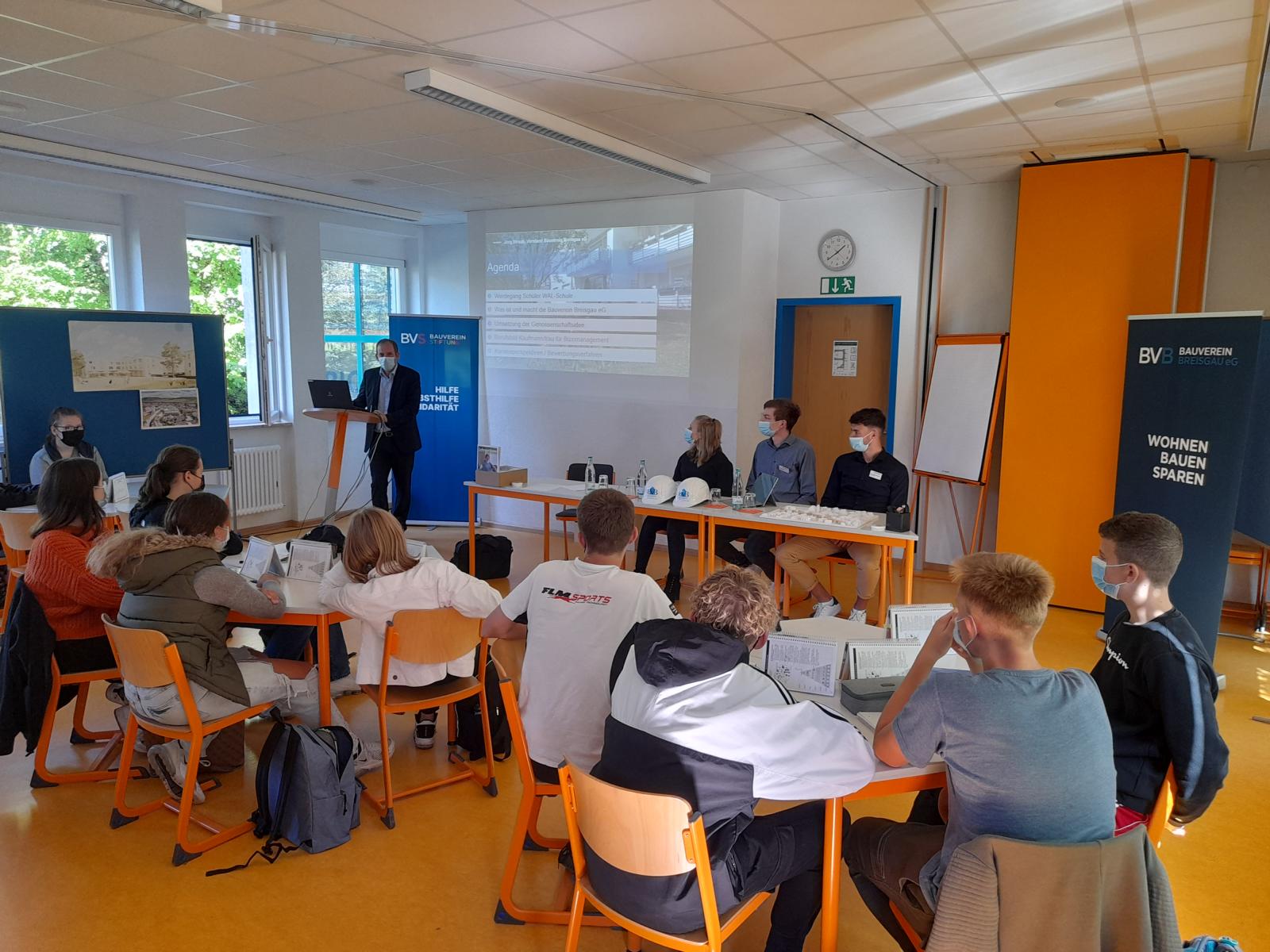 Jörg Straub, Geschäftsführender Vorstand des Bauvereins Breisgau, mit den Auszubildenden Elias Schätzle-König, Nelli Mast und Michael Adler beim Workshop an der WAL-Schule K1600 Bauverein